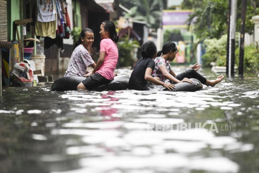Anak-anak bermain saat terjadi banjir di daerah Kelurahan Gunung, Kebayoran Baru, Jakarta, Sabtu (18/1/2020).
