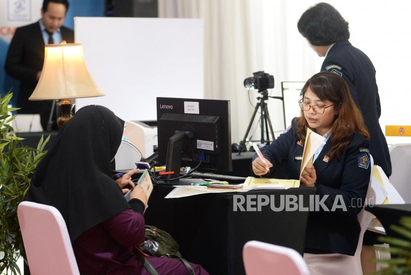 Petugas Imigrasi membatu warga membuat paspor pada Festival Keimigrasian 2020 di Gedung Pusat BRI, Jakarta, Sabtu (18/1).