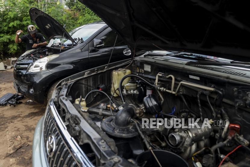 Seorang warga melihat kondisi mobilnya yang mogok di Kompleks TVRI Kemandoran, Kebayoran Lama, Jakarta, Ahad (19/1). Cuaca panas, terlebih yang tingkatannya ekstrem, bisa menyebabkan sejumlah masalah pada mobil.