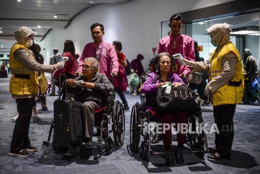 Petugas mendeteksi suhu tubuh (thermal scanner) penumpang pesawat di Terminal 3 Bandara Soekarno Hatta, Tangerang, Banten, Rabu (22/1).