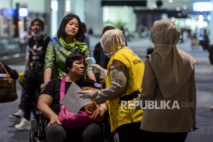 Di bawah koordinasi Dinas Kesehatan DKI Jakarta, petugas mendeteksi suhu tubuh penumpang pesawat di Terminal 3 Bandara Soekarno Hatta, Tangerang, Banten, Rabu (22/1).
