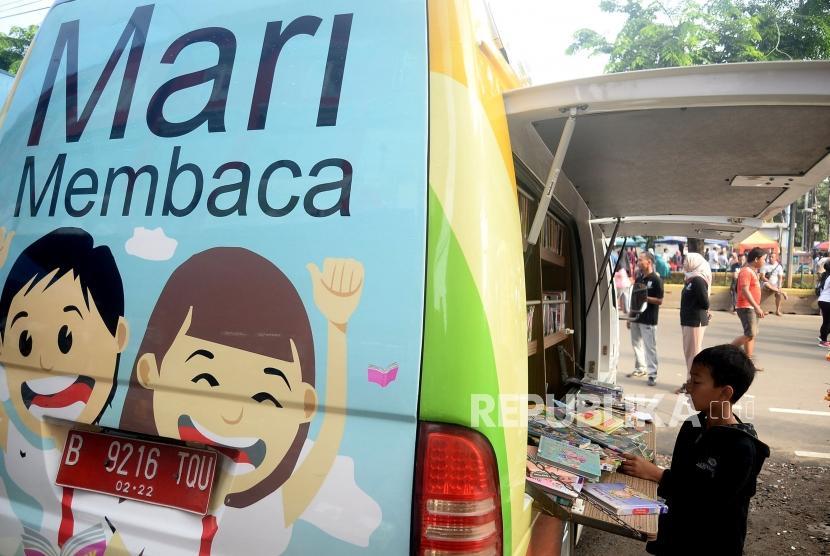 Anak-anak mencari  buku bacaan di perpustakaan keliling saat belangsungnya Hari Bebas Kendaraan Bermotor di Kawasan Rawamangun, Jakarta, Ahad (26/1). Ikapi mencatat peningkatan perhatian pemerintah dan warga terhadap dunia buku