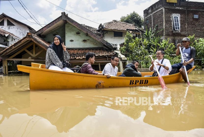Banjir dan Longsor Terjang 5 Kecamatan di Kabupaten Bandung. Sejumlah warga menggunakan perahu melintasi genangan banjir di Jalan Katapang Andir, Kecamatan Baleendah, Kabupaten Bandung. Foto ilustrasi.
