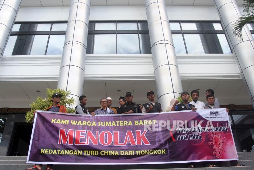 Belasan warga yang tergabung dalam Forum Masyarakat Minangkabau (FMM) menggelar spanduk yang berisikan menolak kedatangan turis China, saat mengadakan audensi di kantor Dewan Perwakilan Daerah Sumatera Barat, Padang, Senin (27/1/2020).