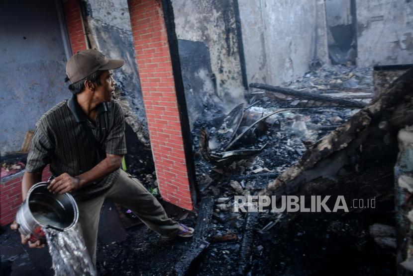 Warga memadamkan api  saat kebakaran di permukiman padat penduduk kawasan Peninggaran Timur, Kebayoran Lama, Jakarta, Senin (27/1).