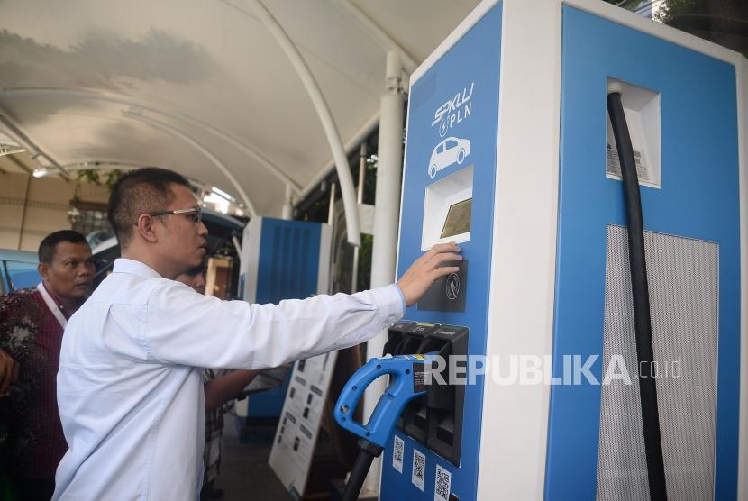 Petugas membatu pengemudi taxi melakukan pengisian daya pada mobil listrik di Stasiun Pengisian Kendaraan Listrik Umum (SPKLU) PLN di Kantor PLN Disjaya, Gambir, Jakarta, Selasa (28/1).