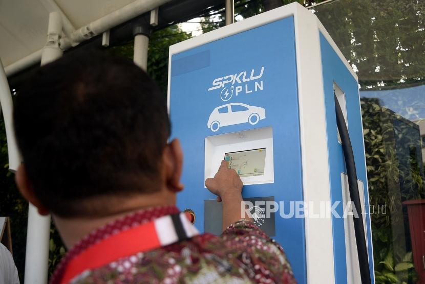 Petugas membatu pengemudi taxi melakukan pengisian daya pada mobil listrik di Stasiun Pengisian Kendaraan Listrik Umum (SPKLU) PLN di Kantor PLN Disjaya, Gambir, Jakarta, Selasa (28/1).(Republika/Prayogi)