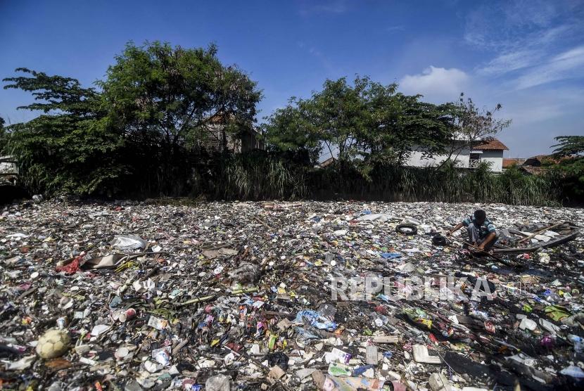 Seorang warga menggunakan perahu untuk memilah sampah plastik di tumpukan sampah yang memenuhi sungai Citepus yang bermuara ke Sungai Citarum di Kampung Bojong Citepus, Kecamatan Dayeuhkolot, Kabupaten Bandung, Selasa (28/1).