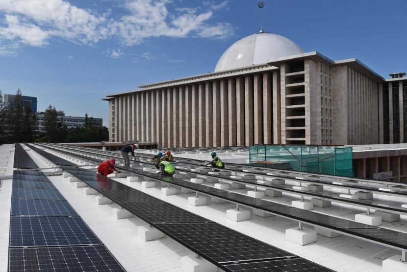 Sejumlah pekerja memasang panel listrik tenaga surya di atap Masjid Istiqlal di Jakarta, Selasa (28/1/2020).