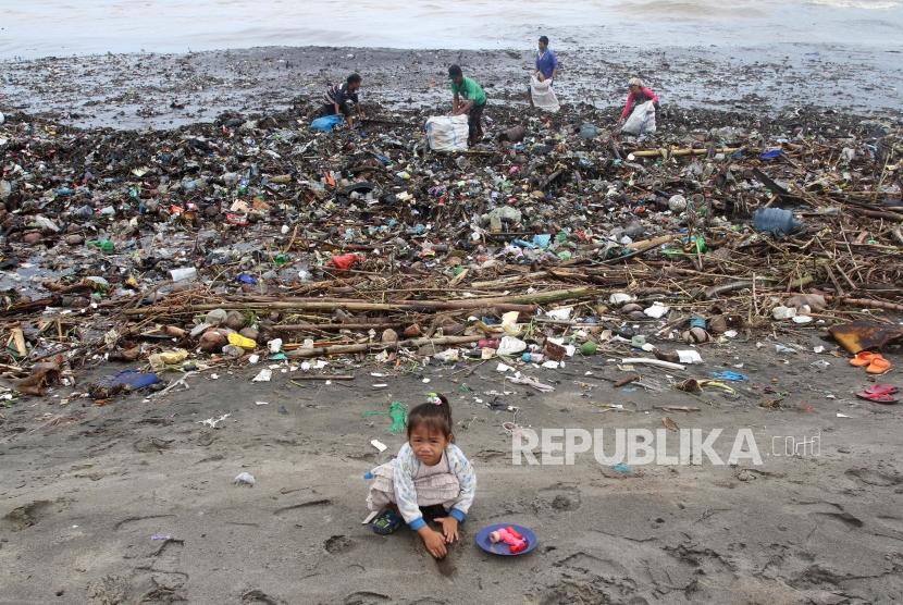 Sejumlah warga mengambil sampah yang bertumpuk di kawasan Pantai Muaro Lasak, Padang, Sumatera Barat, Rabu (29/1/2020).