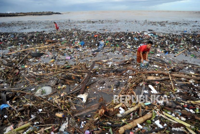 Anak-anak mengumpulkan kaleng dan botol minuman bekas, di antara sampah yang memenuhi kawasan Pantai Muaro Lasak, Padang, Sumatera Barat, Rabu (29/1/2020).