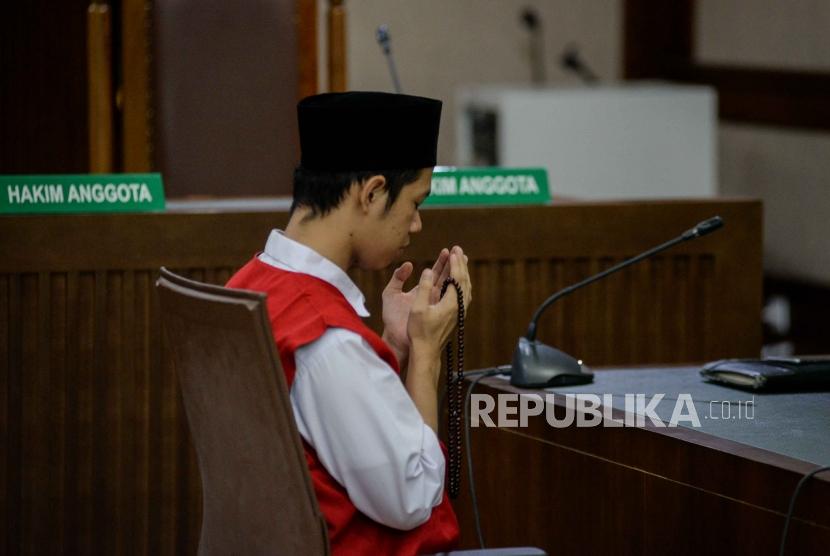 Terdakwa kasus aksi unjukrasa pelajar pembawa bendera merah putih di gedung DPR Dede Lutfi Alfiandi memanjatkan doa saat akan mengikuti sidang putusan di Pengadilan Negeri Jakarta Pusat, Kamis (30/1).