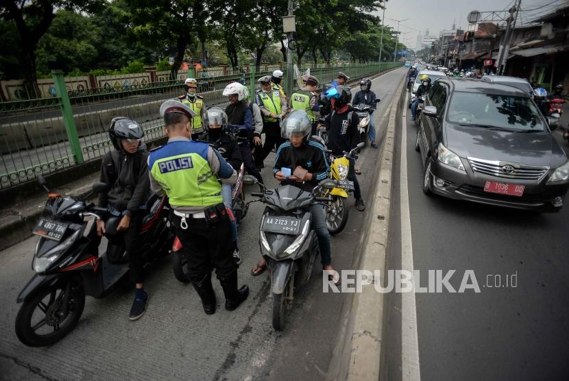 Petugas merazia sejumlah kendaaran yang menerobos jalur khusus Transjakarta. Tim gabungan TNI-Polri merazia kendaraan di jalur Transjakarta Jatinegara, Jaktim.