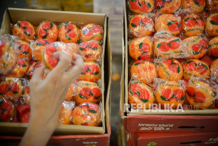 Pembeli memilah buah impor dikawasan Pasar Induk Kramat Jati, Jakarta Timur.