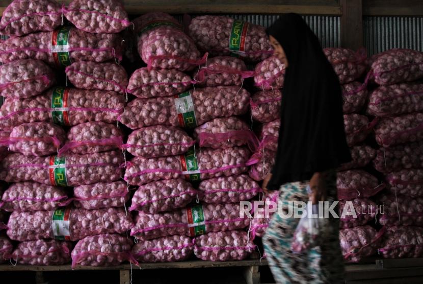 Pedagang membawakan bawang putih impor dari China  ke pembelinya di pasar tradisional Baruga, Kendari, Sulawesi Tenggara, Rabu (5/2/2020).