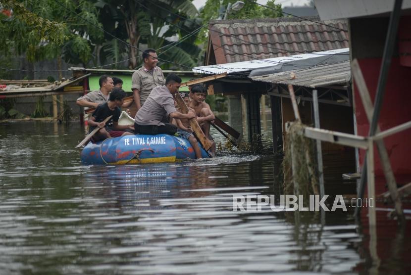 Sejumlah petugas mengevakuasi warga saat banjir di kawasan Perumahan Periuk Damai, Kota Tangerang, Banten, Kamis (6/2).