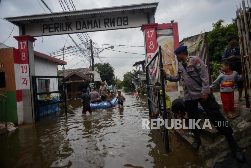 Sejumlah warga menaiki perahu karet saat banjir di kawasan Perumahan Periuk Damai, Kota Tangerang, Banten, Kamis (6/2). Toilet portabel disiagakan di sejumlah lokasi banjir di kawasan Periuk.