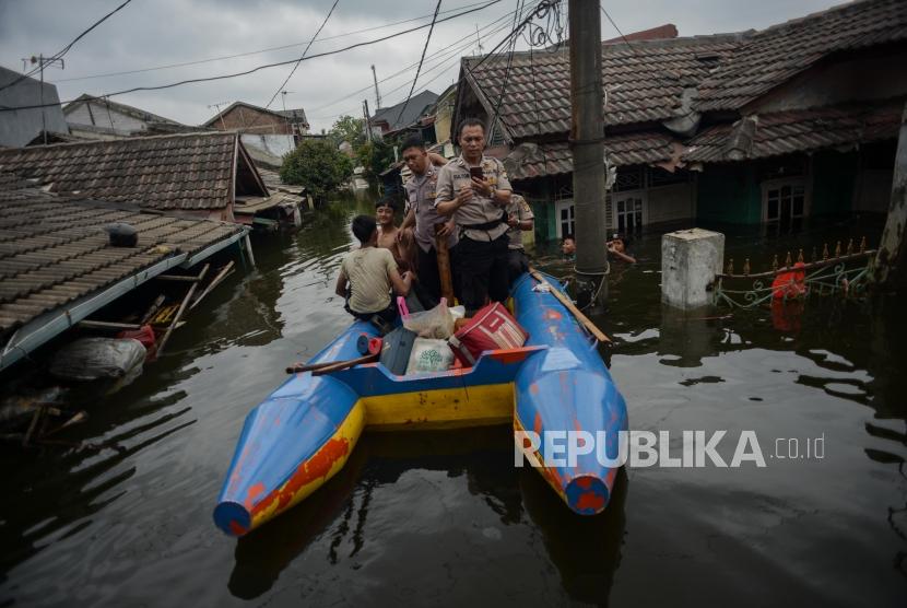 Sejumlah warga bersama Petugas Kepolisian menaiki perahu karet saat banjir di kawasan Perumahan Periuk Damai, Kota Tangerang, Banten, Kamis (6/2).