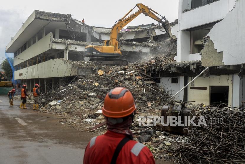 Pekerja membongkar gedung menggunakan alat berat di lokasi proyek revitalisasi kawasan Taman Ismail Marzuki (TIM) di Jakarta, Jumat (7/2).