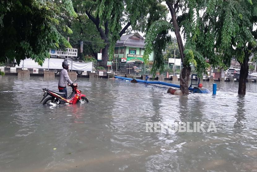 Seorang pengendara motor mendorong motornya yang mogok saat melintas di Jl. Sunter Kemayoran Jakarta yang terendam banjir, Sabtu (8/2).