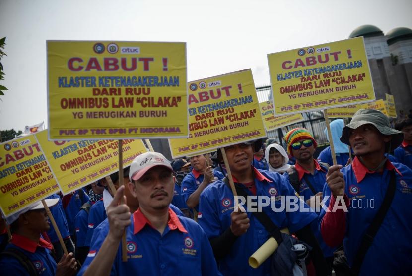Sejumlah massa buruh melakukan aksi unjuk rasa di depan Gedung DPR RI, Jakarta, Rabu (12/2).