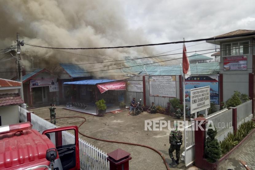 Petugas gabungan berusaha memadamkan api yang membakar gedung saat terjadi kerusuhan di Rumah Tahanan Negara (Rutan) Kelas II B Kabanjahe, Kabupaten Karo, Sumatera Utara, Rabu (12/2/2020).