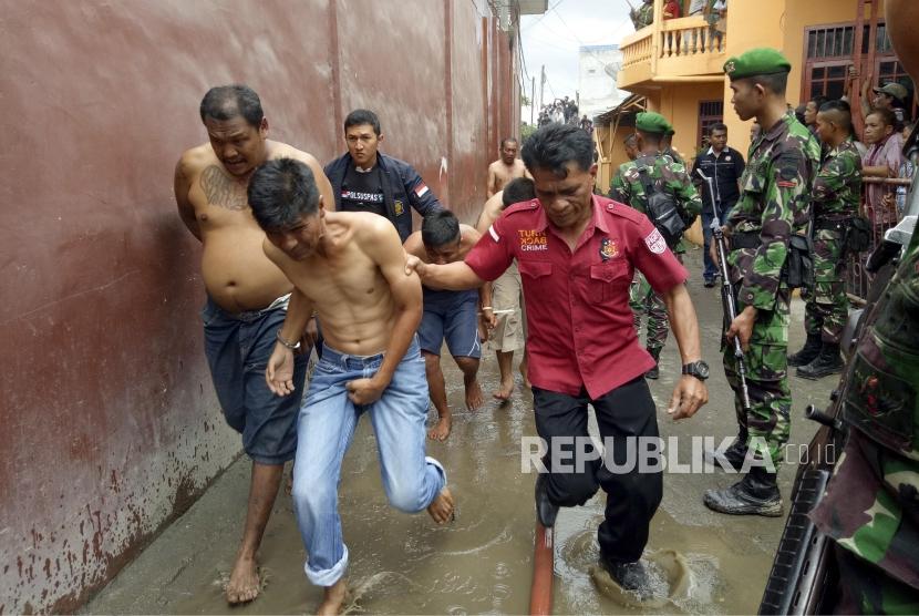Petugas gabungan menggiring narapidana pascakerusuhan di Rumah Tahanan Negara (Rutan) Kelas II B Kabanjahe, Kabupaten Karo, Sumatra Utara, Rabu (12/2/2020). Sebagian warga binaan Kabanjahe dievakuasi ke lapas lain setelah kerusuhan.