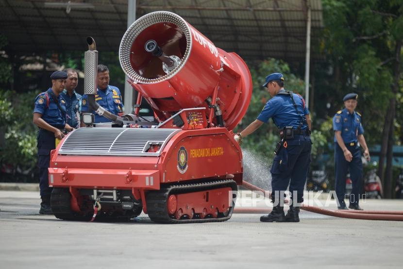 Pemadam Kebakaran mengoperasikan Unit Robot Pengurai Material Kebakaran LUF60 saat demonstrasi robot pemadam kebakaran di Halaman Dinas Pemadam Kebakaran DKI Jakarta, Kamis (13/2).