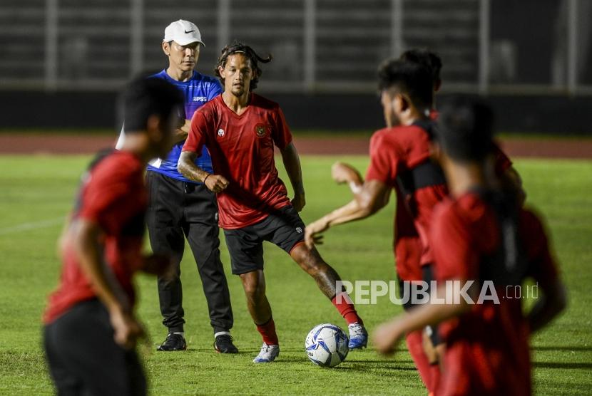 Pemain Timnas Indonesia Irfan Bachdim (ketiga kiri) dan pelatih Timnas Indonesia Shin Tae Yong (kedua kiri) saat mengikuti latihan perdana di Stadion Madya, Senayan, Jakarta, Jumat (14/2).