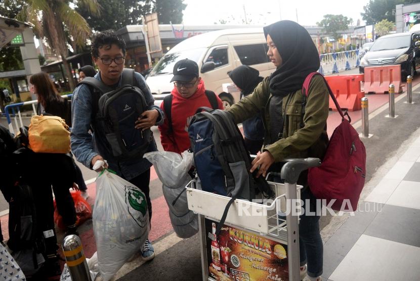 Sejumlah Warga Negara Indonesia (WNI) yang telah menjalani observasi Corona di Natuna menata barang bawaan untuk melanjutkan perjalanan ke daerah masing-masing saat tiba di bandara Halim Perdanakusuma, Jakarta, Sabtu (15/2).