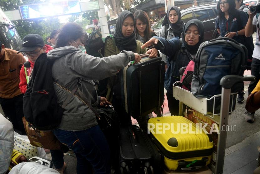 Sejumlah Warga Negara Indonesia (WNI) yang telah menjalani observasi Corona di Natuna menata barang bawaan untuk melanjutkan perjalanan ke daerah masing-masing saat tiba di bandara Halim Perdanakusuma, Jakarta, Sabtu (15/2).