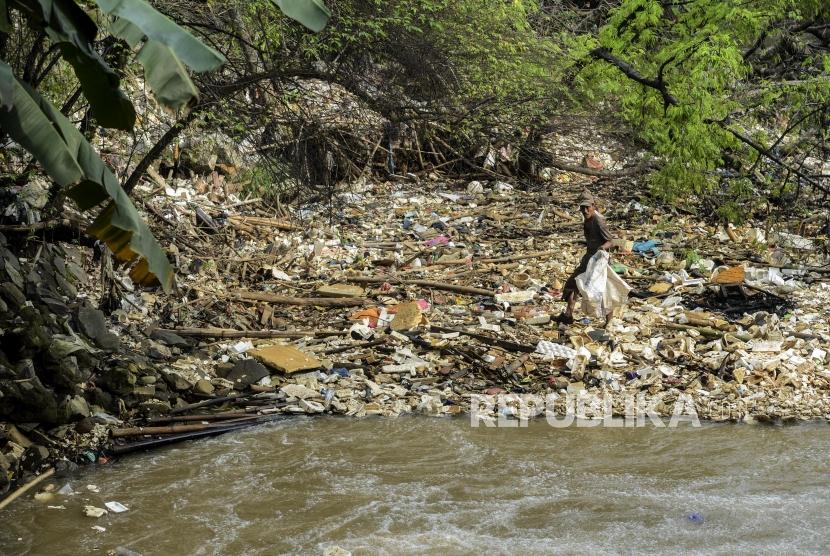 Seorang pemulung mencari sampah yang berada di aliran Sungai Kalibaru, Cibinong, Kabupaten Bogor, Jawa Barat, Senin (17/2).