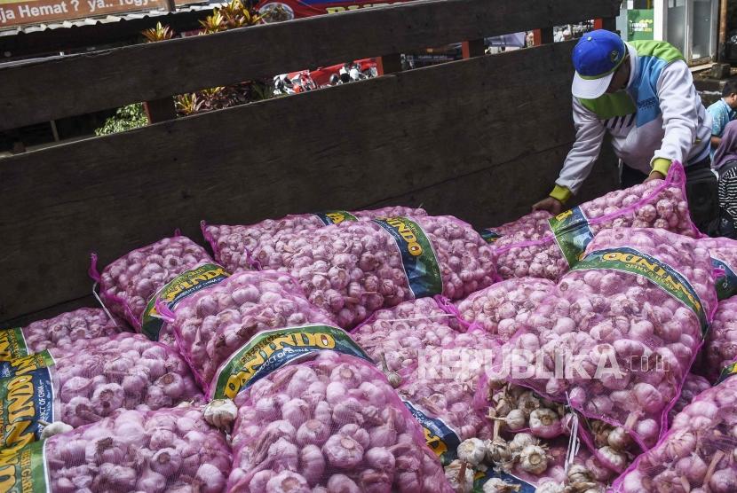 Pedagang memilih bawang putih saat operasi pasar 