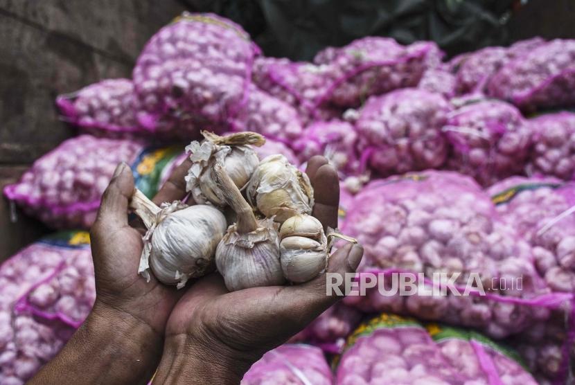 Pedagang menunjukan bawang saat operasi pasar di Pasar Kosambi, Kota Bandung. Saat ini harga bawang putih turun menjadi Rp 38 ribu hingga 40 ribu per kilogram. Ilustrasi.