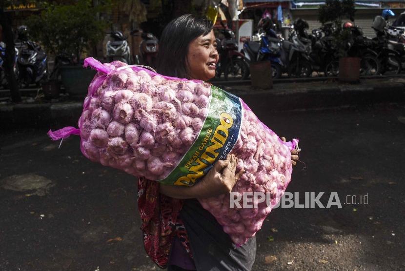 Pedagang membawa karung yang berisi bawang putih saat operasi pasar di Pasar Kosambi, Kota Bandung, Jumat (10/5). Kementerian Perdagangan menyatakan, telah menerbitkan Surat Persetujuan Impor (SPI) Bawang Putih sebanyak 34.825 ton hingga awal bulan ini.