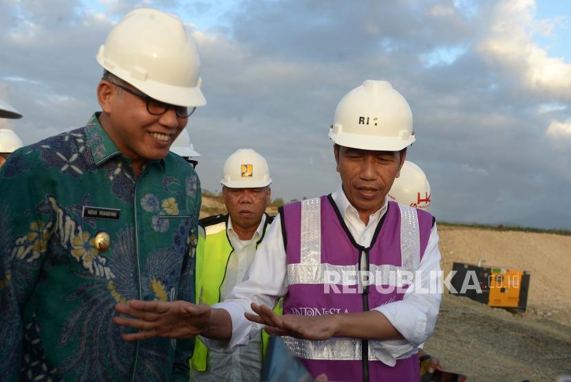 Presiden Joko Widodo (kanan) berbincang dengan Plt Gubernur Aceh Nova Iriansyah (kiri) saat meninjau perkembangan pembangunan Seksi IV jalan tol di Desa Indra Puri, Kabupaten Aceh Besar, Aceh, Jumat  (21/2/2020). (ilustrasi)