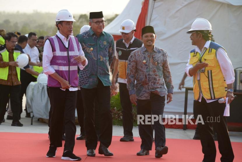 Presiden Joko Widodo (kiri) didampingi Plt Gubernur Aceh, Nova Iriansyah (kedua kiri) berjalan saat meninjau perkembangan pembangunan Seksi IV jalan tol di Desa Indra Puri, Kabupaten Aceh Besar, Aceh, Jumat ( 21/2/2020).(AMPELSA/ANTARA FOTO)