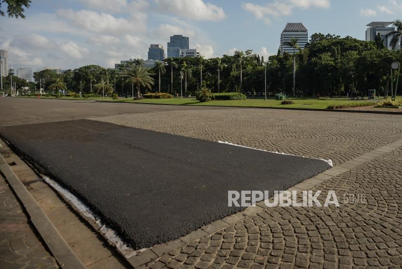 Kondisi lapisan aspal di area percobaan pengasopalan lintasan Formula E non permanen di kawasan Monumen Nasional, Jakarta, Ahad (23/2).(Republika/Thoudy Badai)