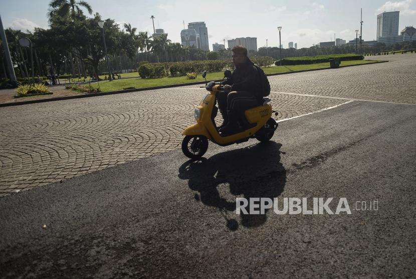 Sejumlah pengendara motor listrik melintas di area percobaan pengasopalan lintasan Formula E non permanen di kawasan Monumen Nasional, Jakarta, Ahad (23/2).
