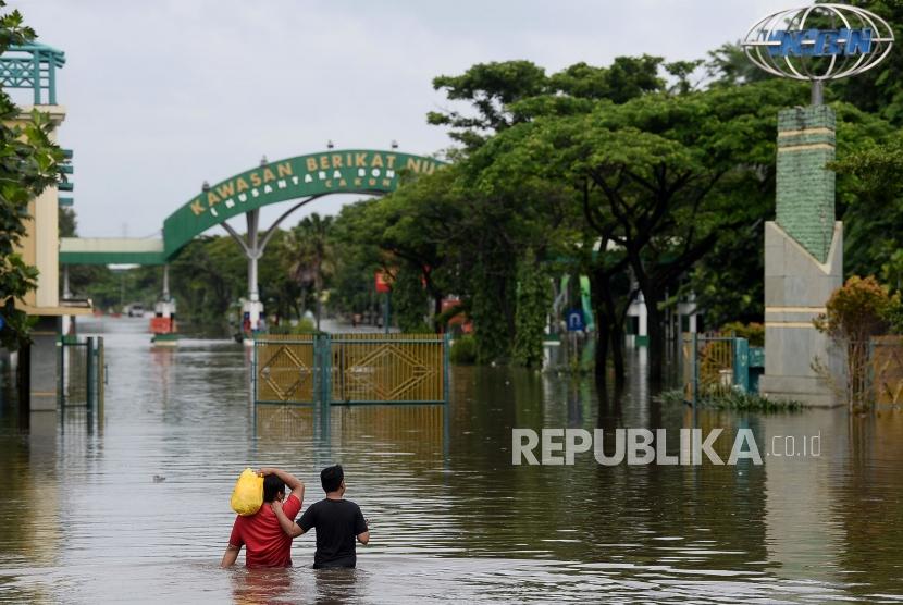 Pekerja melintasi banjir di Kawasan Berikat Nusantara (KBN), Cilincing, Jakarta (ilustrasi)