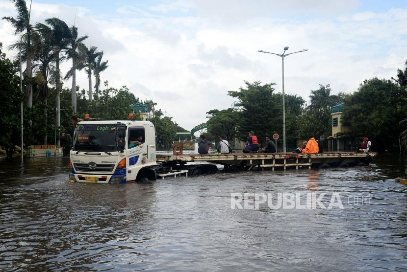 Netizen Keluhkan Banjir Hingga Listrik Padam di Media Sosial. Foto: Sejumlah pekerja melintasi banjir dengan menumpang truk di Kawasan Berikat Nusantara (KBN), Cilincing, Jakarta, Senin (24/2).