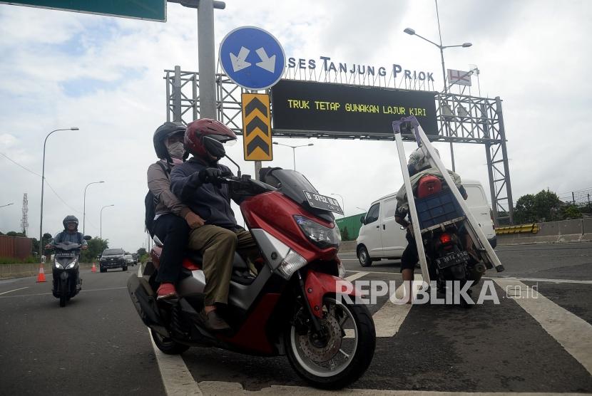 Pengendara sepeda motor masuk ke Jalan Tol Akses Tanjung Priok untuk menghindari banjir di Jakarta Utara, Senin (24/2).