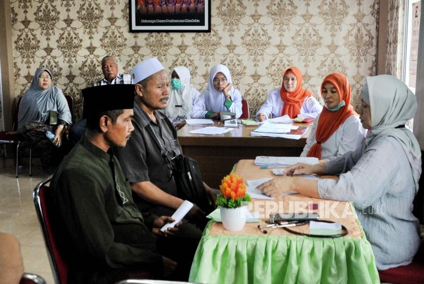 Lima Masa Perkembangan Kebijakan Kesehatan Ibadah Haji. Foto: Dua calon jemaah haj berkonsultasi pada dokter saat pemeriksaan dan pembinaan kesehatan Calon Jemaah Haji di Puskesmas Merdeka Palembang, Sumsel, Senin (24/2/2020).