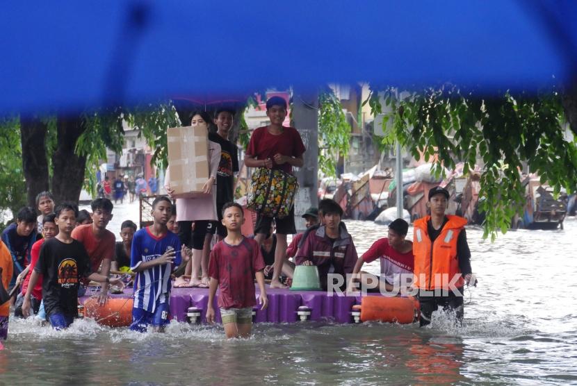 Warga bersama-sama mendorong pelampung rakitan untuk mengangkut motor dan masyarakat agar terhindar dari banjir di jalan Sunter Kemayoran Jakarta, Selasa (25/2).