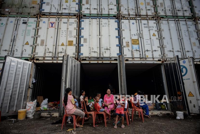 Warga korban banjir beraktivitas saat mengungsi di dalam peti kemas kosong di Kampung Sepatan, Rorotan, Jakarta, Kamis (27/2).