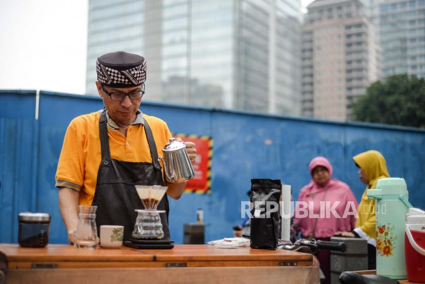 Calon wakil gubernur DKI Nurmansjah Lubis berdagang kopi di area CFD Jalan Jenderal Sudirman, Jakarta, Ahad (2/3).