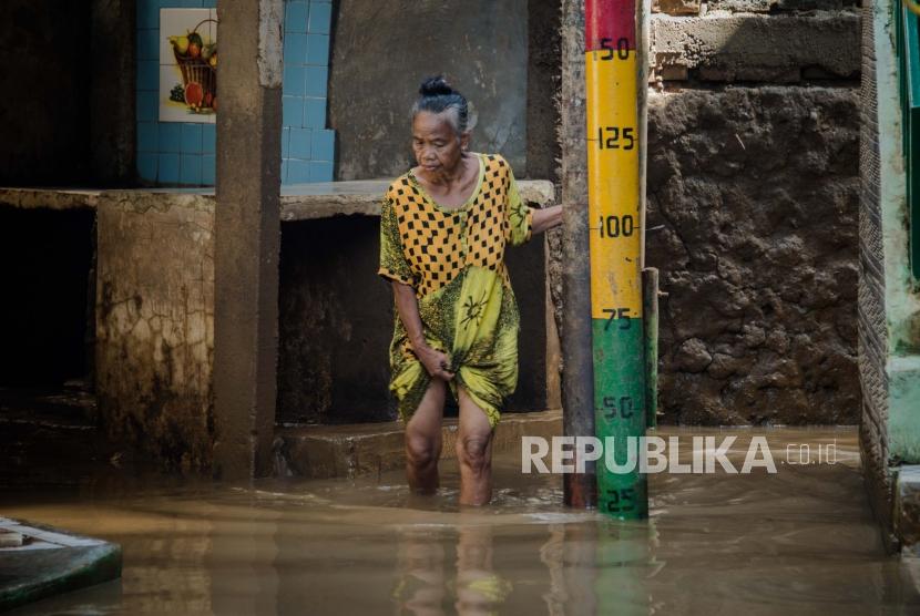 Warga berjalan di area yang terendam banjir di kawasan Kebon Pala, Jatinegara, Jakarta, Senin (2/3).(Republika/Thoudy Badai)