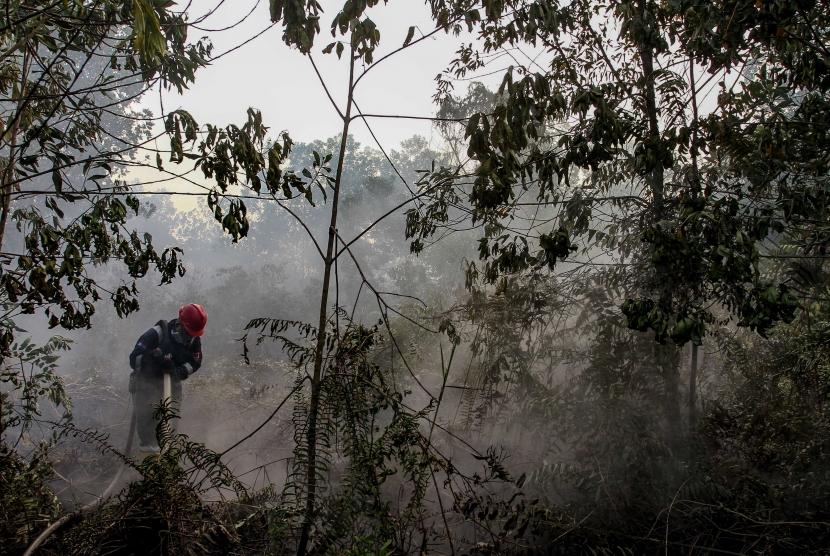 Pertugas Manggala Agni menyemprotkan air ke lahan gambut yang terbakar (ilustrasi)