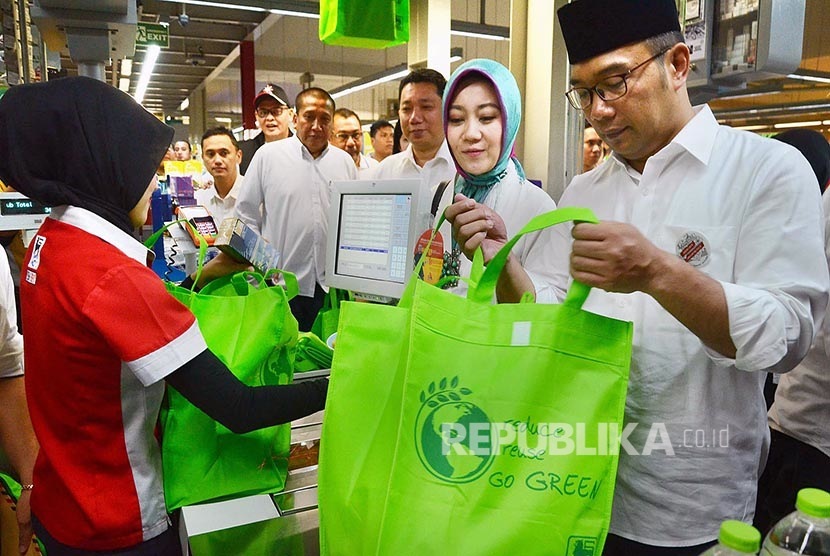  Wali Kota Bandung Ridwan Kamil bersama istri  berbelanja dengan menggunakan kantong belanja untuk menyukseskan program pengurangan kantong plastik di Superindo, Kota Bandung, Ahad (21/2). (Republika/Edi Yusuf)