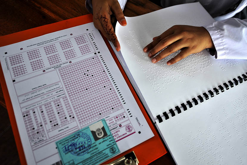 Siswa penyandang disabilitas netra membaca soal dalam bentuk braille saat mengikuti ujian nasional (UN) di SLBA Yapti Makassar, Sulawesi Selatan, Senin (4/4). (Antara/Yusran Uccang)